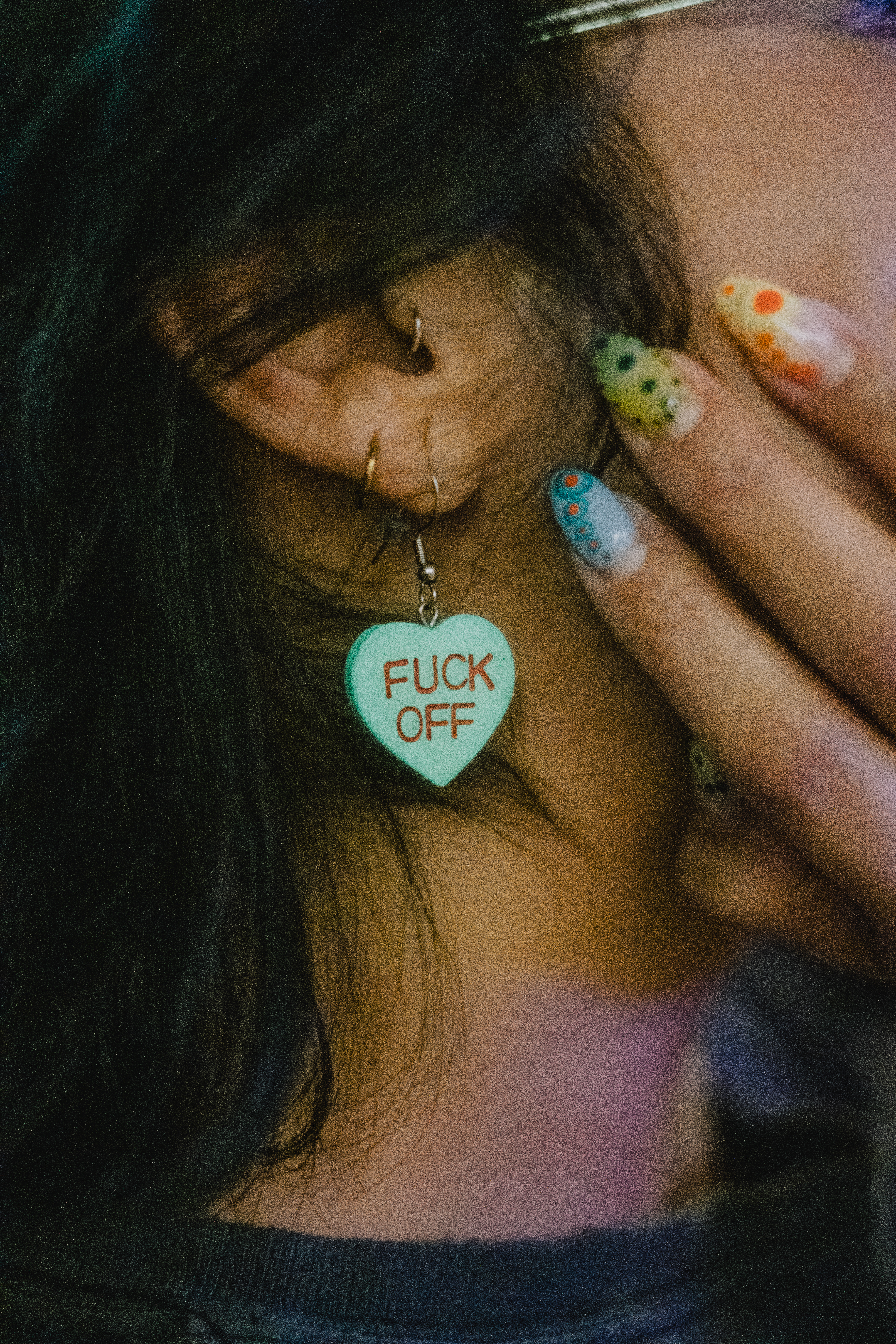 Kayla de Leon with a sick manicure and an earring that says fuck off